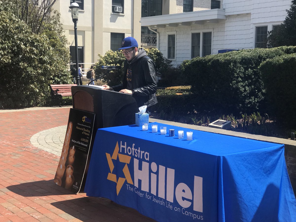 HofstraU's tweet photo. Six Hours for Six Million. 

Hofstra students pay tribute to the six million Jewish people who perished in the Holocaust by reading aloud the names of the children who lost their lives. 

*In front of Hofstra Hall until 4pm for #HolocaustMemorialDay. https://t.co/pGJDR1Sug2