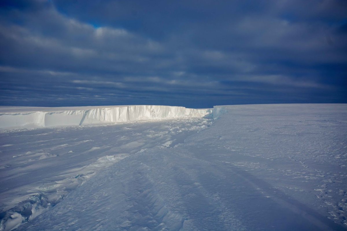 AntarcticReport's tweet photo. A rare close up look at the Halloween Crack on the 150m thick Brunt Ice Shelf; the white stuff at the bottom is sea ice which forms as the crack opens up. This crack extends 50km across the shelf, one of two threatening Halley Station, pic Stewart Titterington @BAS_News https://t.co/nhVRPzWKyK