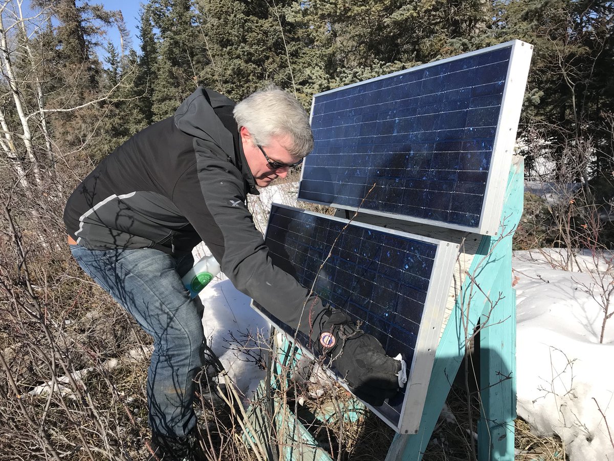 James Locke, IT consultant, dusts off solar panels near Alexandra Falls (Enterprise). The panels power remote cameras for spring break up along the Hay River. EMO (Town of Hay River) and volunteers monitor the river for potential flooding each spring. Early days. No movement yet.