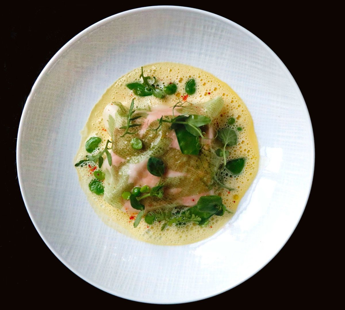 “LE SAUMON” from LE GRILL’s $65 prix fixe menu: Salmon cooked in a light saffron broth, herb raviolo. (@joelrobuchonusa)