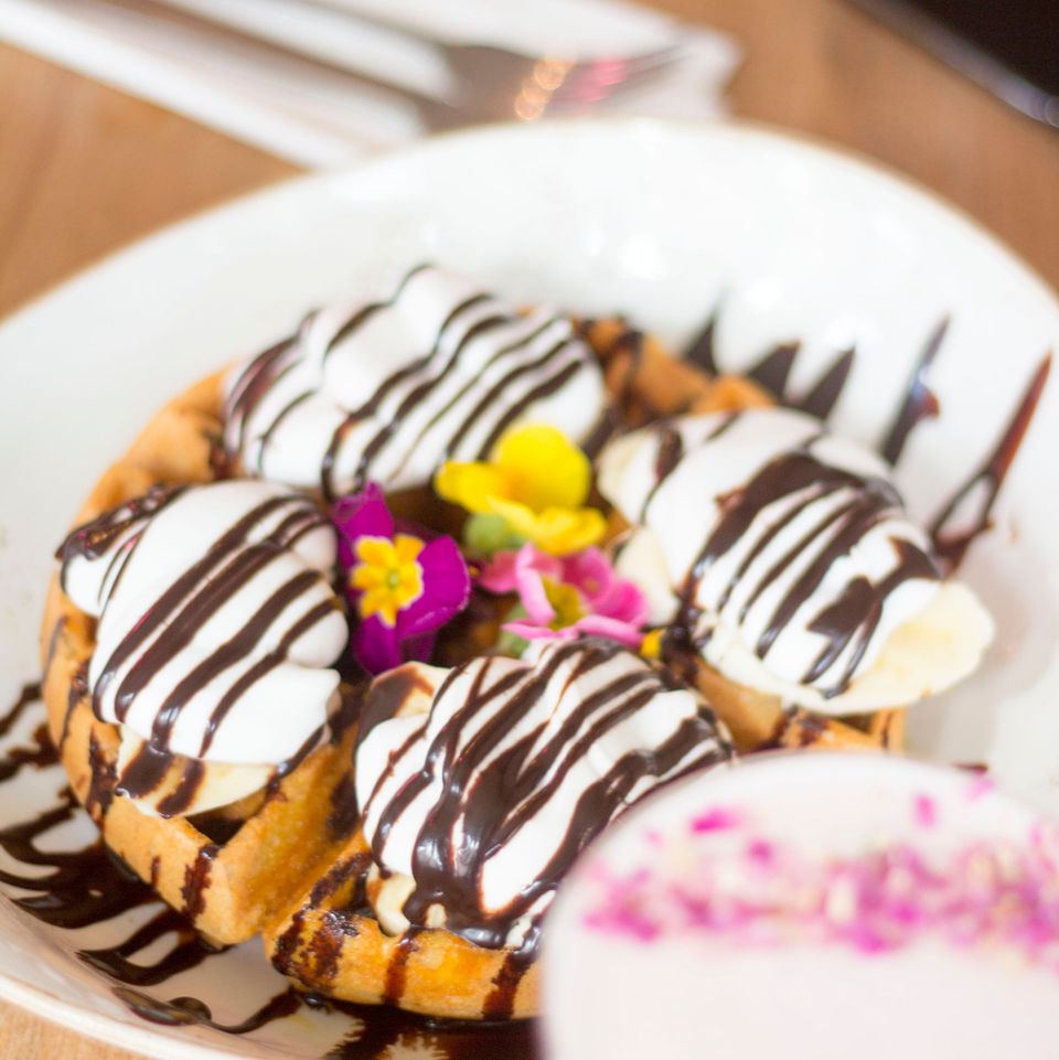 Sitting in the sun with fluffy waffles with banana, coconut cream and drizzled with chocolate🌸 😎