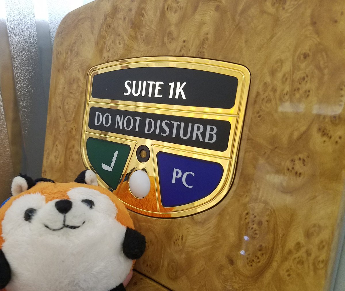 plush fox with a do-not-disturb sign for a suite on an emirates airplane.