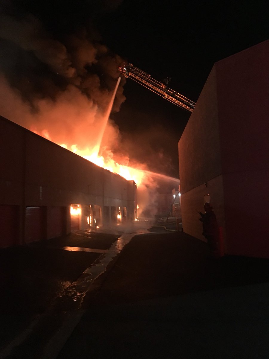 OCFireAuthority's tweet photo. Laguna Hills Structure Fire. 25000 Block of Costeau. 2 story self storage unit. Fire through the roof. 4 alarms. Partial wall and roof collapse. 90 firefighters onscene. Defensive fire attack. No injuries reported. https://t.co/jbNzmhi7rg