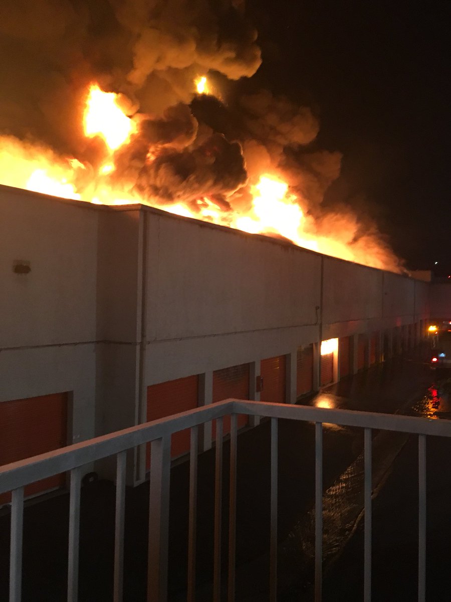 OCFireAuthority's tweet photo. Laguna Hills Structure Fire. 25000 Block of Costeau. 2 story self storage unit. Fire through the roof. 4 alarms. Partial wall and roof collapse. 90 firefighters onscene. Defensive fire attack. No injuries reported. https://t.co/jbNzmhi7rg