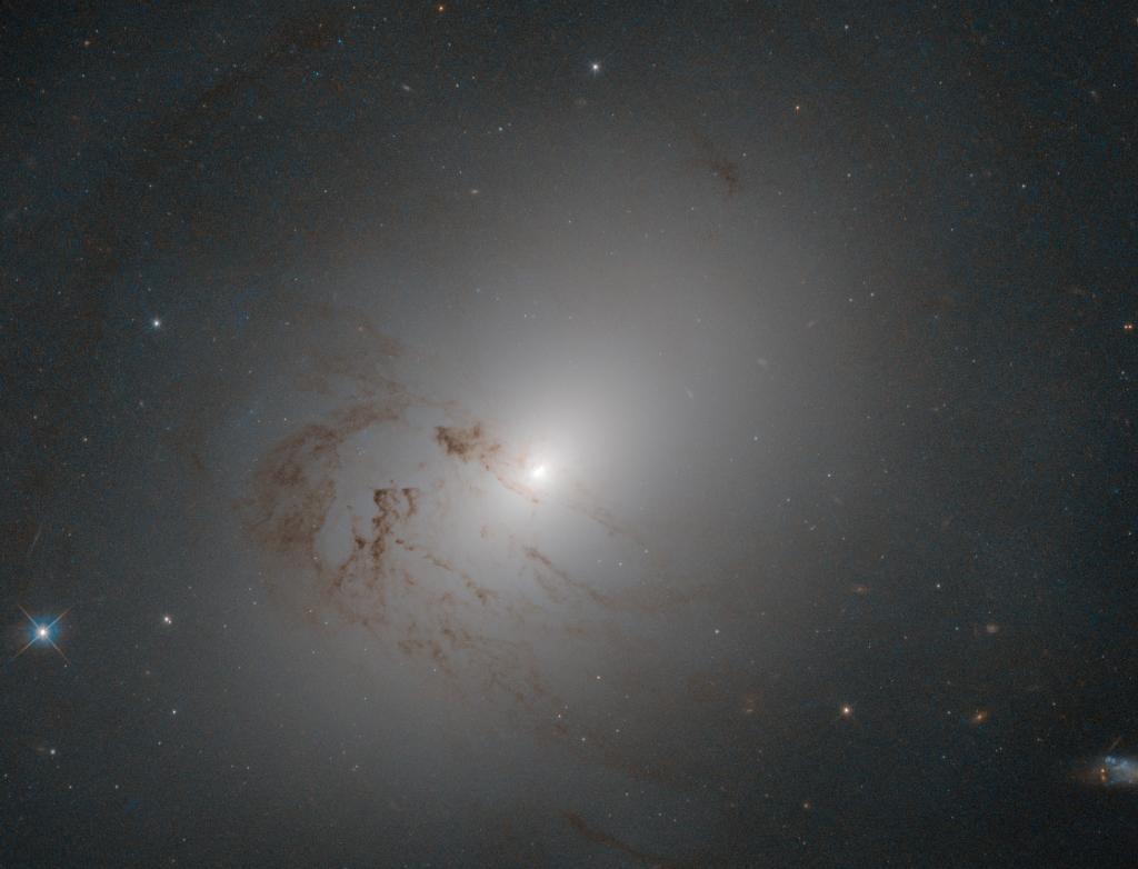 NASA's tweet photo. Located ~80 million light-years from Earth is this cloud-like object, seen by our @NASAHubble telescope. The complex dynamics of the gas in the galaxy suggest that it may have had a turbulent past, including mergers and interactions with other galaxies: https://t.co/fIzm7mj6o4 https://t.co/qNKQu3hxI4