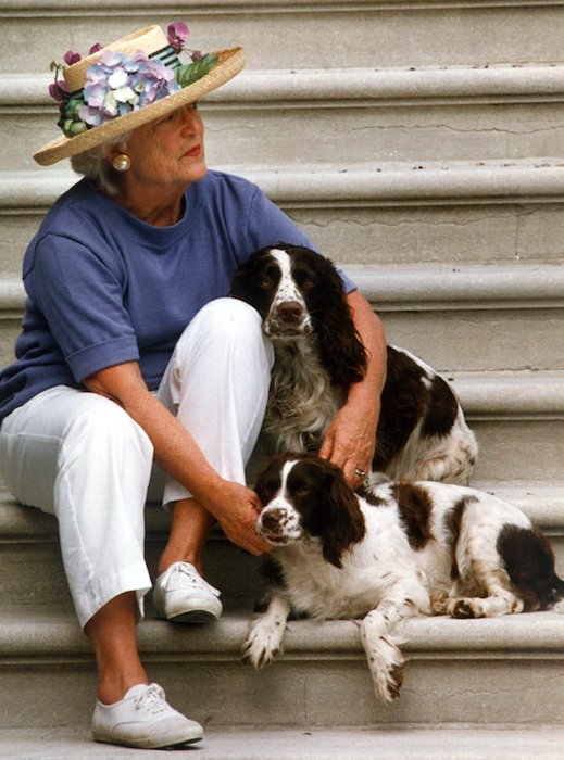 When they weren't traveling together, Barbara Bush would often sit on the South Portico and wait for President Bush to return to the South Lawn via Marine One. Here she is with dogs Millie and Ranger doing just that, in 1991. PS: great hat.