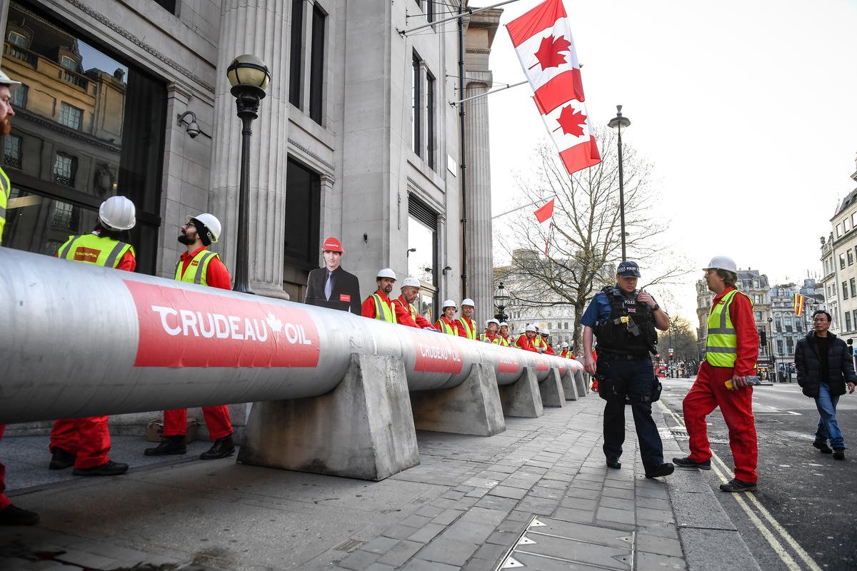 GreenpeaceUK's tweet photo. Greenpeace protesters build massive pipeline around London's Canadian High Commission - from @standardnews https://t.co/bl756YgdQZ https://t.co/IK9YdyL6kJ