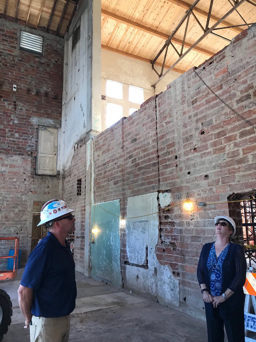 ExtraStepBlog's tweet photo. Hard hat tour of the historic Boynton Beach High School that is being restored as part of Town Square. #Straticon supervisor Jeff Davis and @cityofboy boynton City Manager Lori LaVerriere contemplate the 49-foot ceiling. 10Q @cityofboynton and @BoyntonBeachCRA for the tour! https://t.co/zAFE0GuDn0