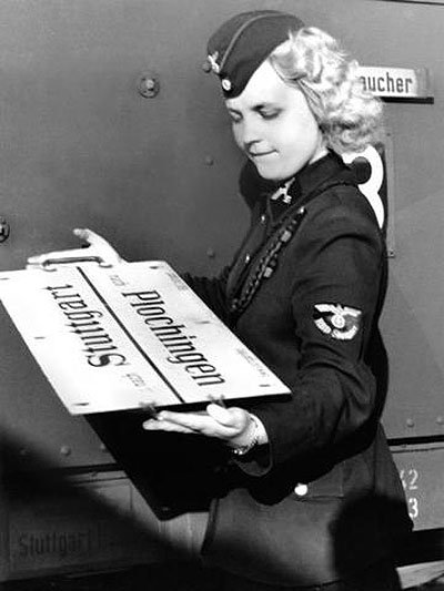 Glockengeist's tweet photo. A Reichsbahn employee. She is holding a railway guide to Southwest Germany. https://t.co/2zCbkT857c