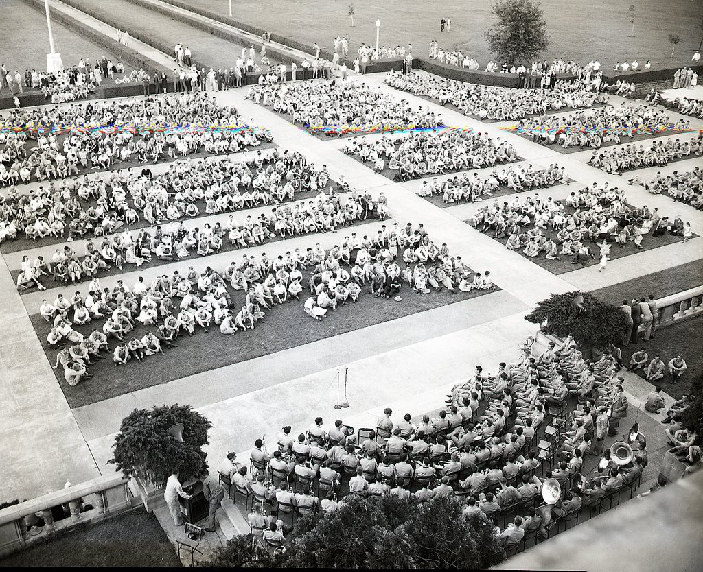 Aggies sitting on the lawn outside of the Administration Building