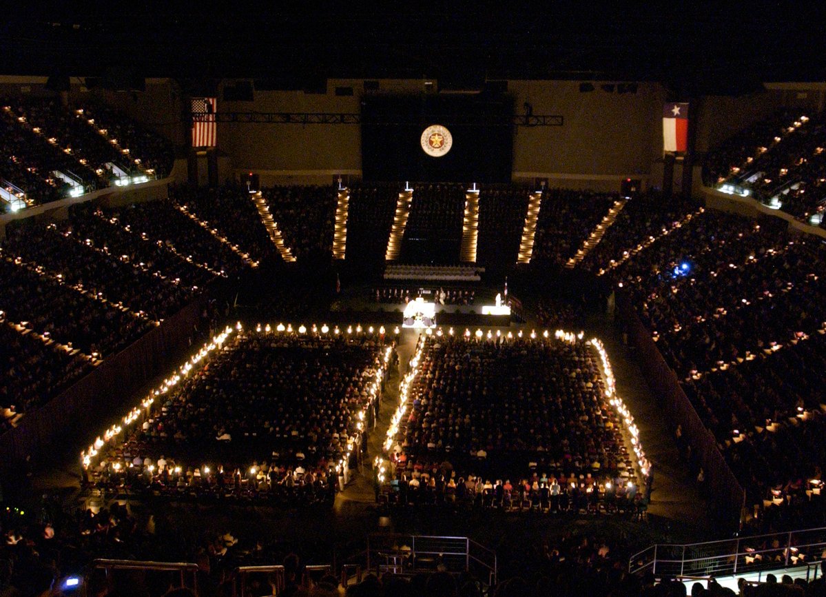Reed Arena filled with Aggies during muster and Aggies on the floor are holding lit candles