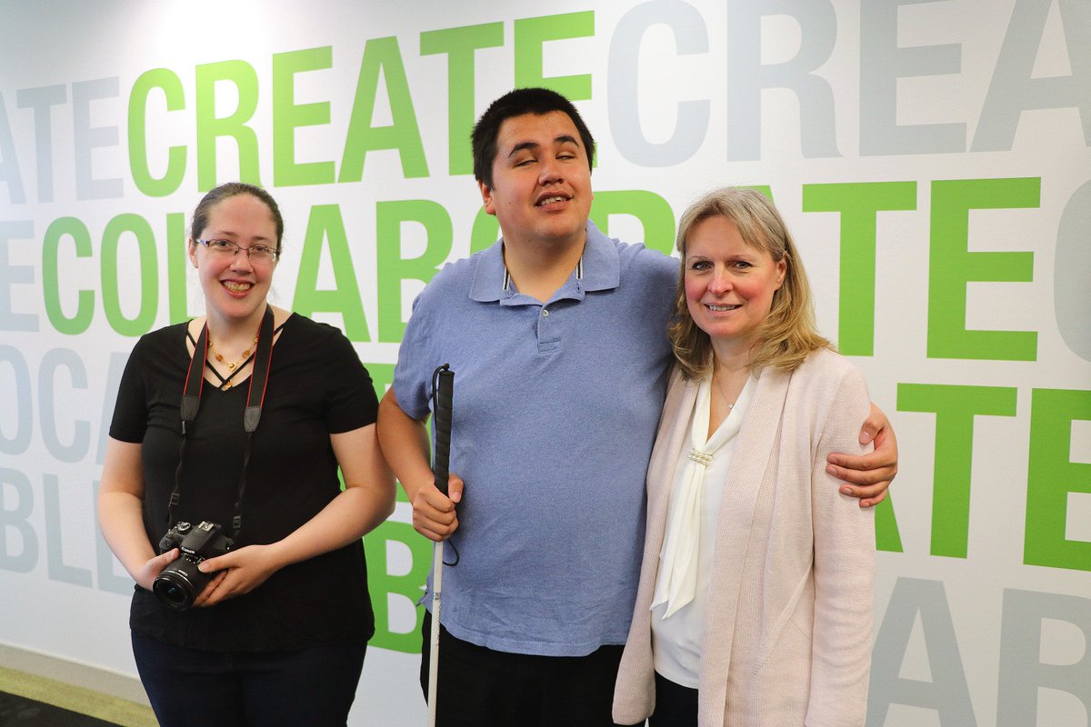 J.R. Bjornson and his YouTube blog videographer pose for a photo in the AMI Toronto boardroom with a staff member.