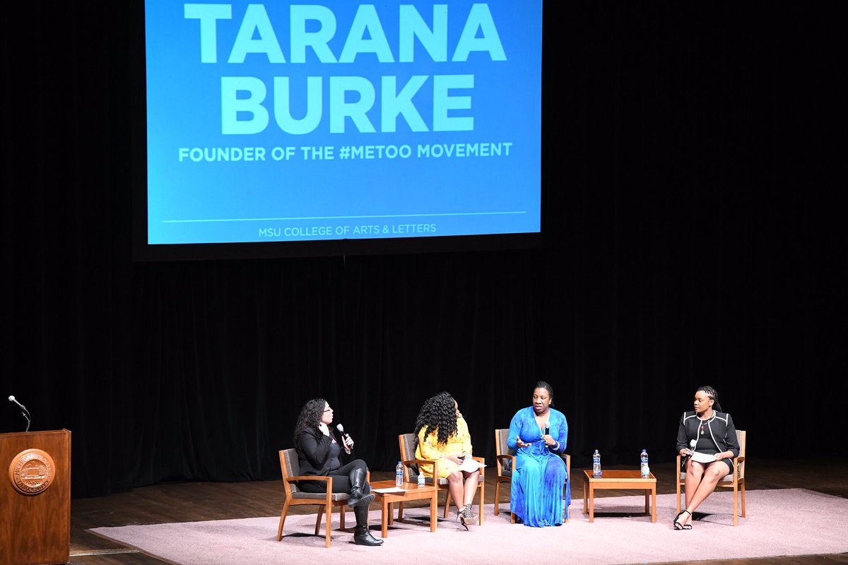 Four women on stage speaking into microphone