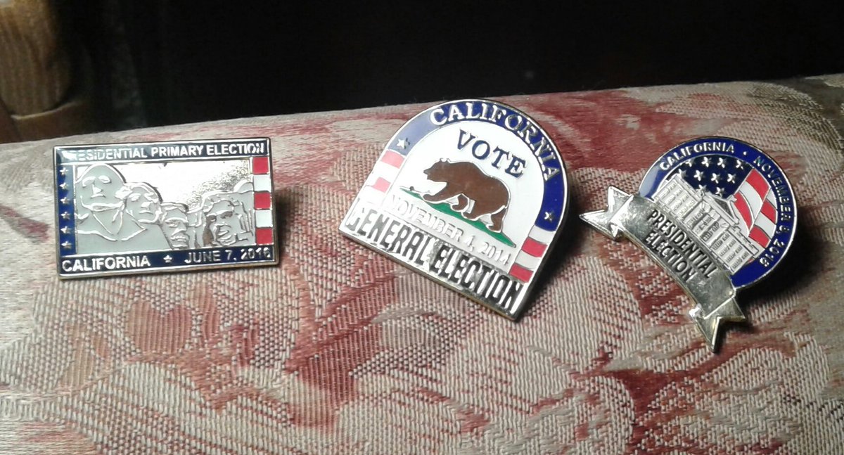 three different lapel pins in red, white and blue and the brass bass color. the first is a rectangle with Mt Rushmore,  reading presidential primary election,  California  (a star)  June 7 2016. the second is dome shape with a bear, the third a banner with the white house.