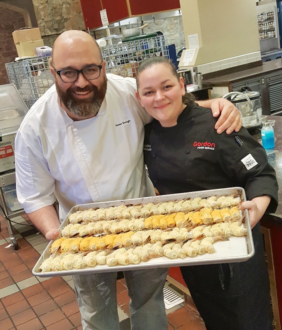 ChefGerryLudwig's tweet photo. More uniquely craveable cuisine at #CIAWOF20 Worlds of Flavor 2018: @GFSDelivers Chef Christine Dively assists Turkish Chef Somer Sivrioglu with live demonstration of his signature Crispy Kataifi (Micro-Shredded Phyllo Dough) Wrapped Prawns. @CIALeadership https://t.co/XuFD3FijLm