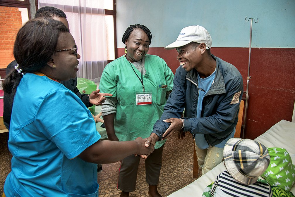 operationsmile's tweet photo. A father thanks post-op nurses Patient and Stephanie from the #DRC after his son received surgery at our mission site in Antsirabe, #Madagascar. #mega4 https://t.co/Mm2ihNA8bG