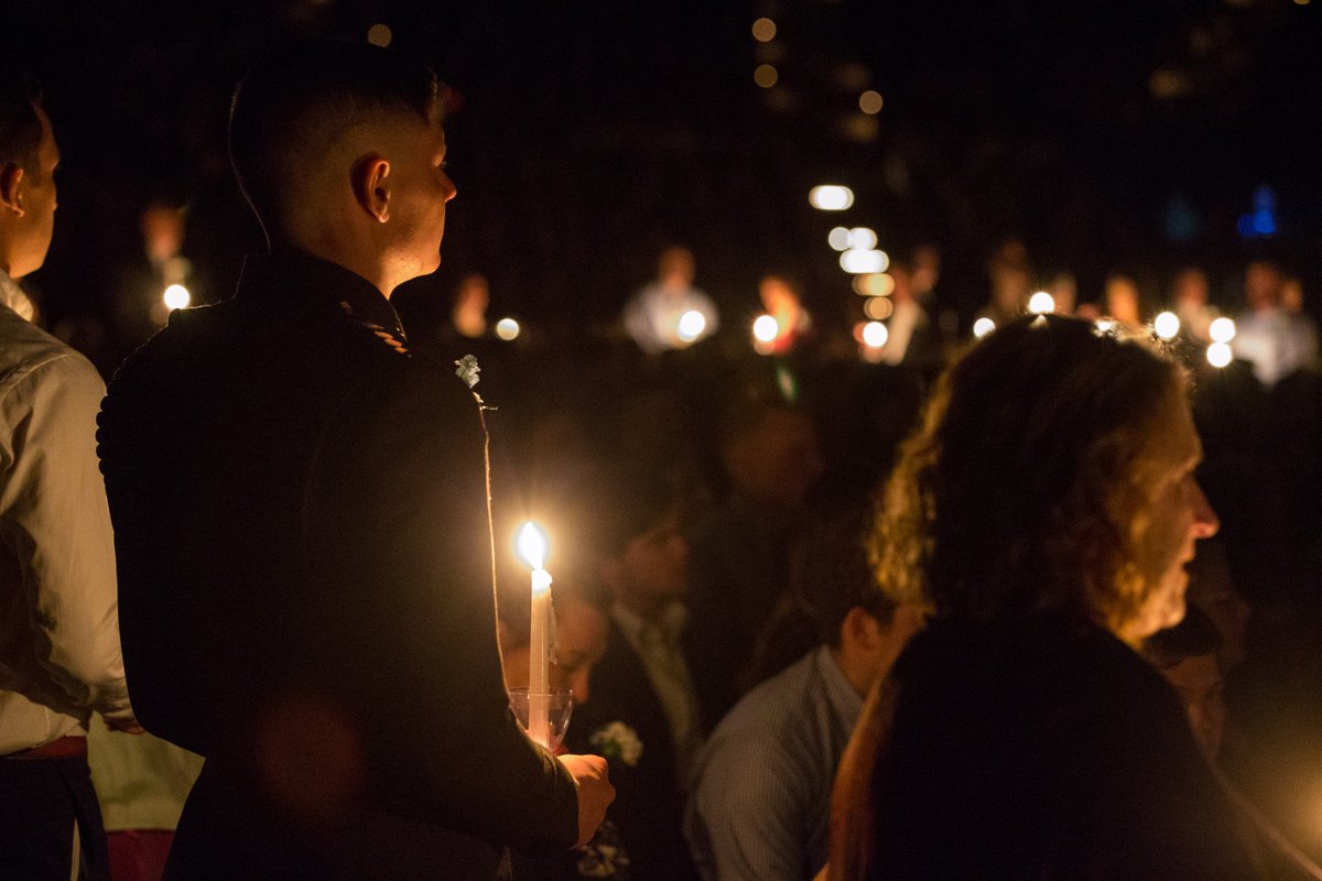 shot of the line of people holding candles from behind