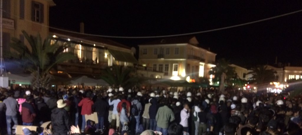 Lesvosolidarity's tweet photo. #BreakingNews : fascists arrived in Sapfous sq to confront the #RefugeesGR who are peacefully protesting since tues. Riot police forms line between. Fascists launched bengal fire&amp;bottles. Refugees form circle to protect women&amp;children and stay calm. Children got injured #lesvos https://t.co/LHoDWrxZIU