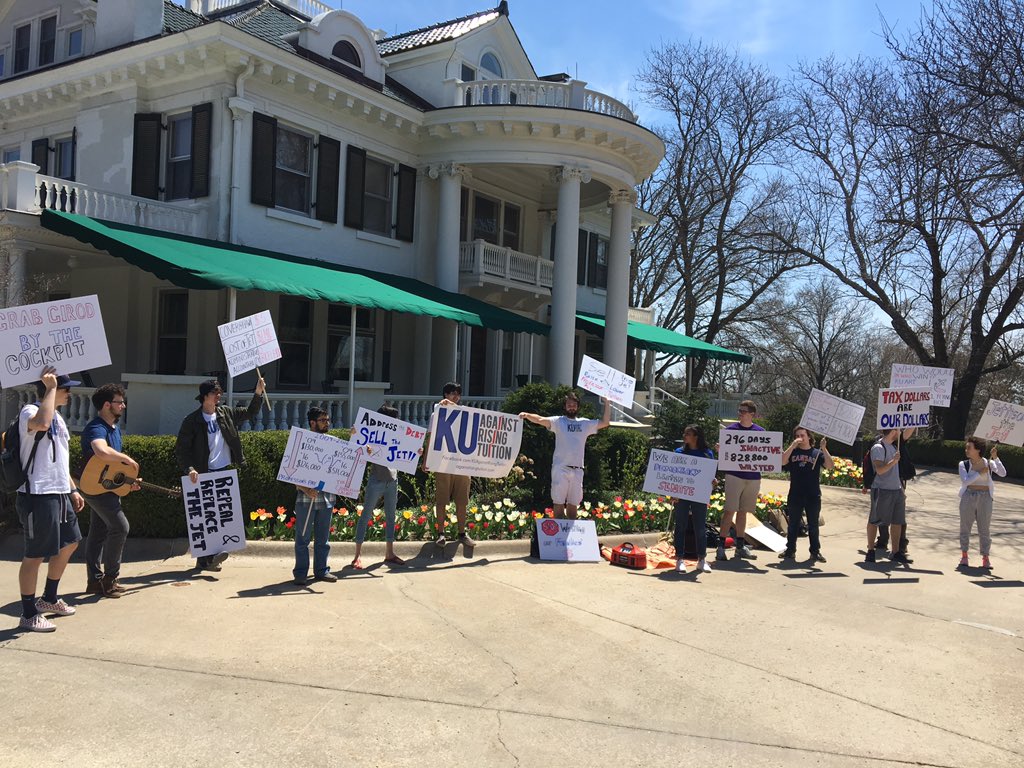 jacksonKMBC9's tweet photo. Happening Now: @kuart2018 are protesting the use of KU's private jet in front of the Chancellor's house. They claim the jet (which operates from state $) is depriving the Lawrence community from millions of dollars. More to come later. @KUJHTV @KSNTNews https://t.co/VVGb96HSg7