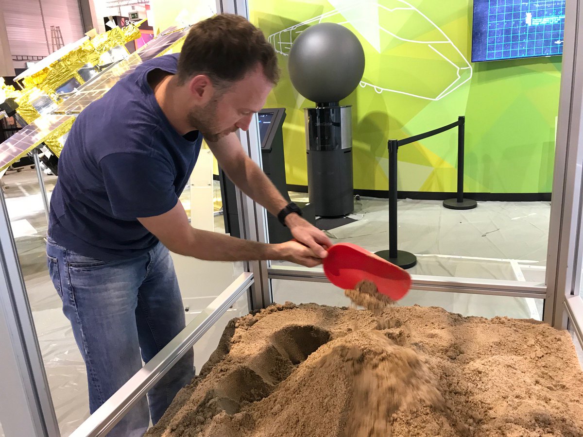 DLR_next's tweet photo. Ich sag' immer: Baut mir den #DLR-Stand ordentlich auf und spielt nicht dauernd mit dem Mars-Sand rum ... Aber so sind sie halt, die Kollegen. @ILA_Berlin https://t.co/JQbGZhh4cp