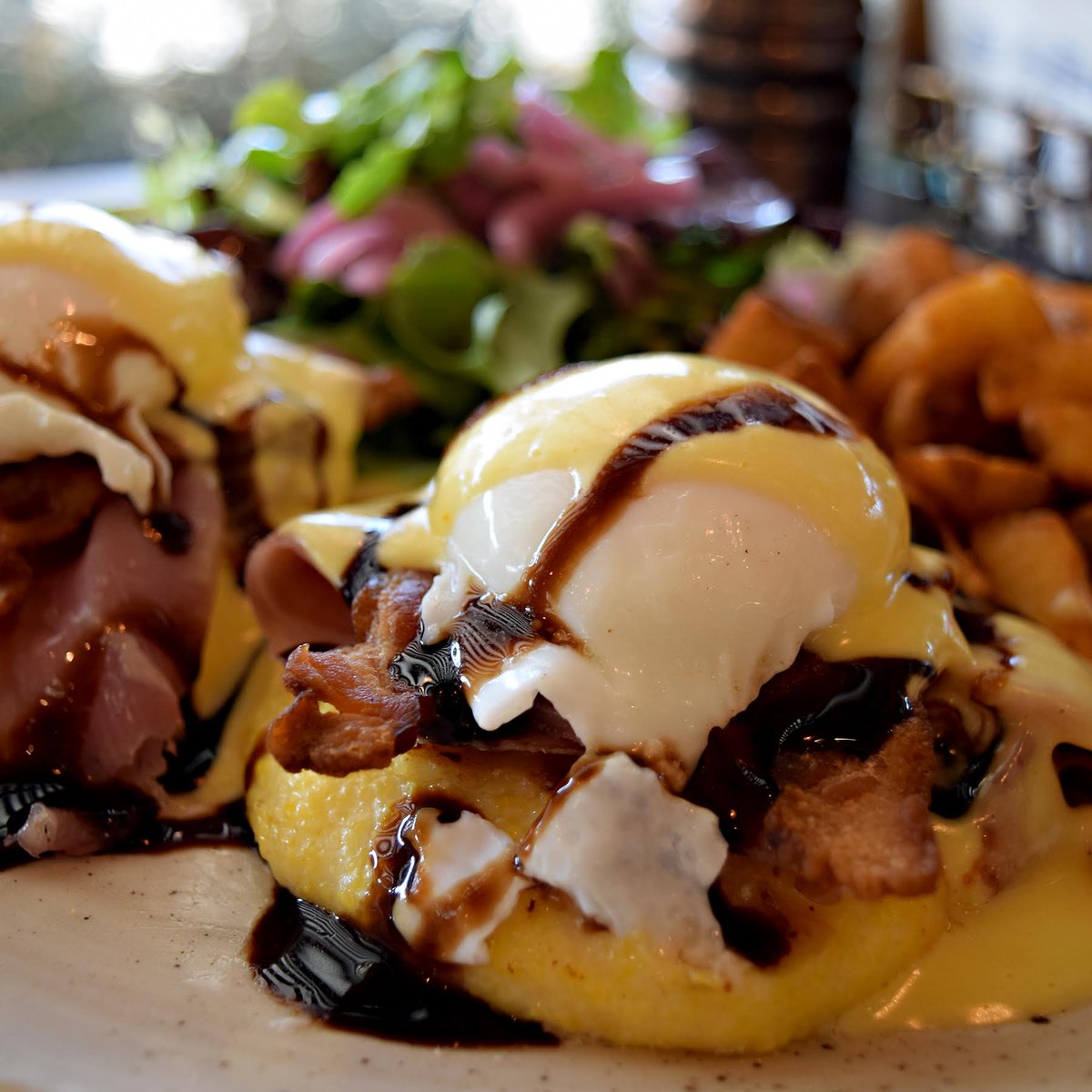 Polenta cakes make a fun, change-of-pace base for our yummy spring benedict. Add some grilled tomato, thinly sliced prosciutto, perfectly poached eggs w/ Hollandaise sauce &amp; a balsamic drizzle–you could do spring yard work all day after this meal (served with crispy home fries)!