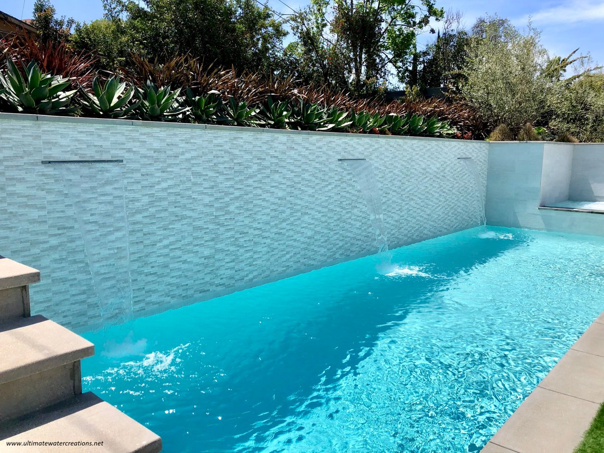 Our finished contemporary swimming pool and spa project with the home owners finishing touches!  They added the beautiful white Ledge Loungers and outdoor wrap around couch with fire pit! #ultimatewatercreations #Pools #poolside #LosAngeles