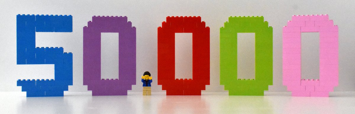 LGS stands in a large LEGO build that says "50,000." He is the comma in this number.