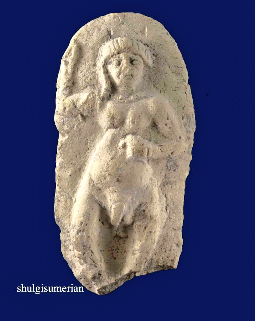 Fired clay plaque of a nude dancing woman with bandy legs, rounded belly suggestive of pregnancy and a heavily swollen pudendum, long curled hair, wearing a necklace, bracelet and thin belt; one hand aloft and the other holding a small item; rounded top, almost complete.

Ur 3 Dy