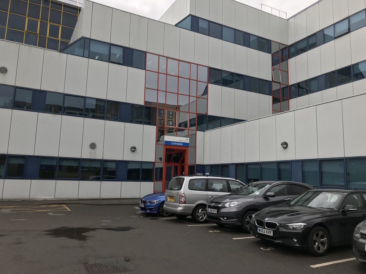 A low-rise building with white and blue glass panelling and cars parked outside, it looks like any other building in any business park in England... but what’s inside?