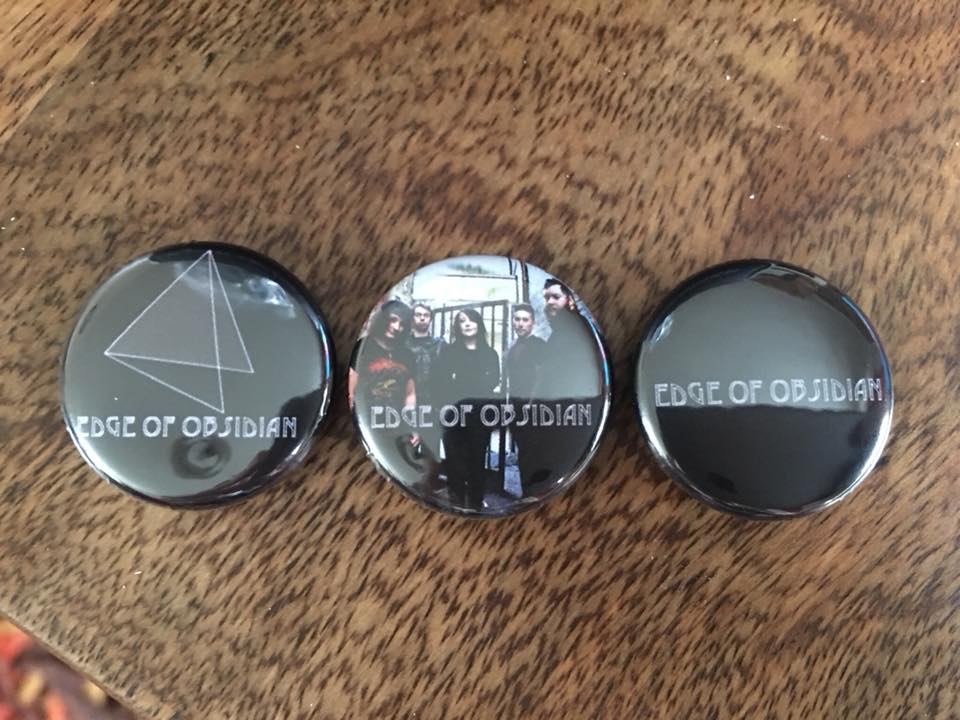 EdgeOfObsidian's tweet photo. Really excited to show you our first lot of band merch! We’ve got badges, lighters and picks which we’ll be selling at our upcoming shows. In a couple of months we’ll also be adding our first ever full album to the list! Stay tuned! 🖤🤘 https://t.co/OoyWOH2wJP