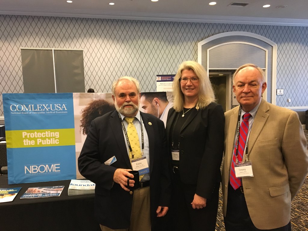NBOME's tweet photo. Ernie Miller Jr, DO and Jimmy Adams, DO from the West Virginia Board of Osteopathic Medicine visiting NBOME VP for Collaborative Assessment & Initiiatives, Sandra Waters at #FSMBAM2018 @TheFSMB https://t.co/bDhSxN7G44