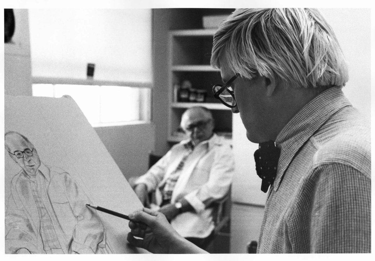 joniweyl's tweet photo. This week's #FlatFileFriday discovery is David Hockney's 3-color lithographic portrait of Billy Wilder from 1976, perfectly capturing the prolific filmmaker. Photo of the artist working on the stone, with Wilder sitting in the background, taken by Sidney B. Felsen. https://t.co/4F4uwe9JVL