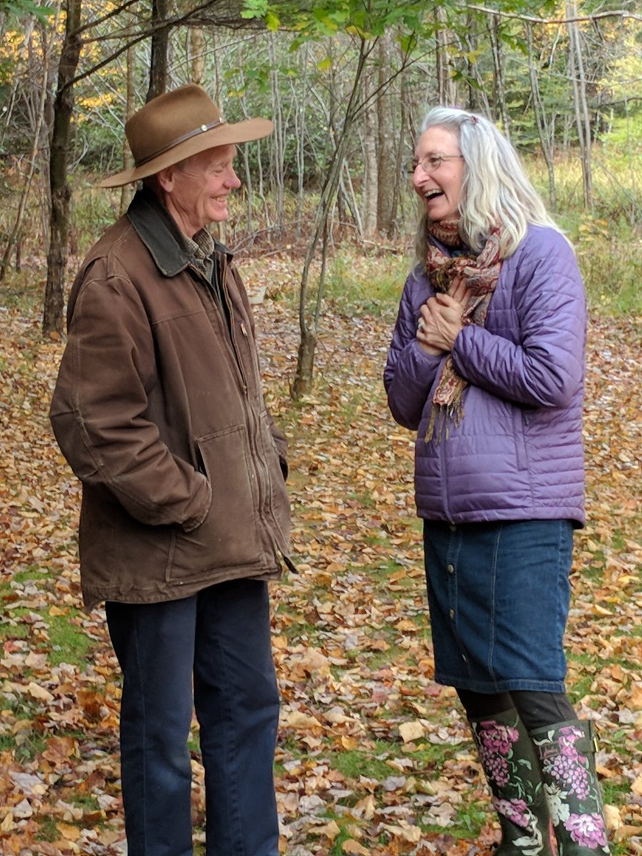 Rosmarie and her mentor Jim Drescher from Windhorse Farm stand together in a beautiful forest located on the property. With Fall in full force, they are surrounded by orange, yellow and brown leaves that cover the floor of the forest. Both are engaged in a good laugh together.