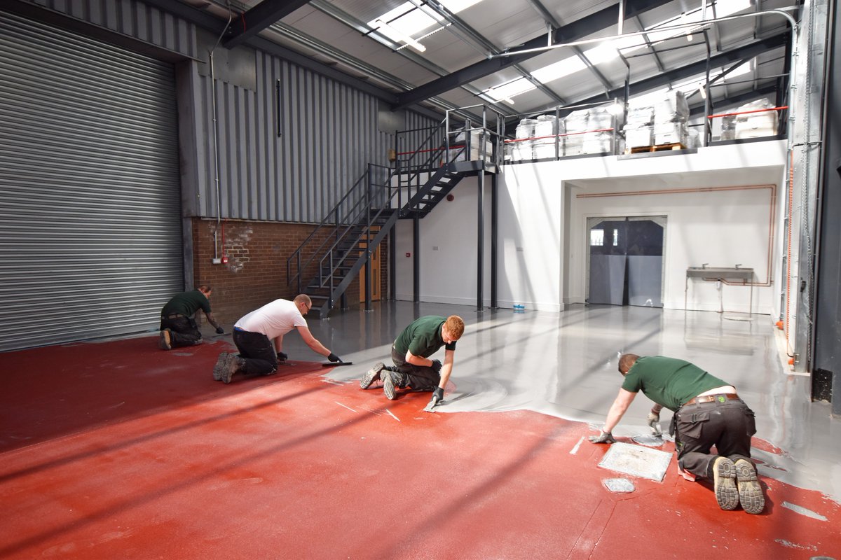 Hard at work laying the heavy-duty resin floor. Now we just need to resist the temptation to leave foot prints in it until it has dried.