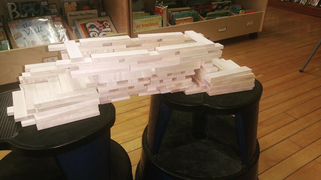 HaskellLibrary's tweet photo. Awesome bridge-building at #MakerWednesday ! Our architects-in-training used every single one of the #kevaplanks in the box, and built a bridge that supported stacks of books! https://t.co/SHB57Cx5R9