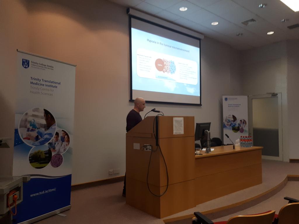 JoanneLysaght's tweet photo. Dr. Stephen Maher giving an excellent talk on the role of miRNAs in improving response to radiotherapy at our inaugural Target meeting on radiobiology #target2018 https://t.co/NhQhb8K3lp