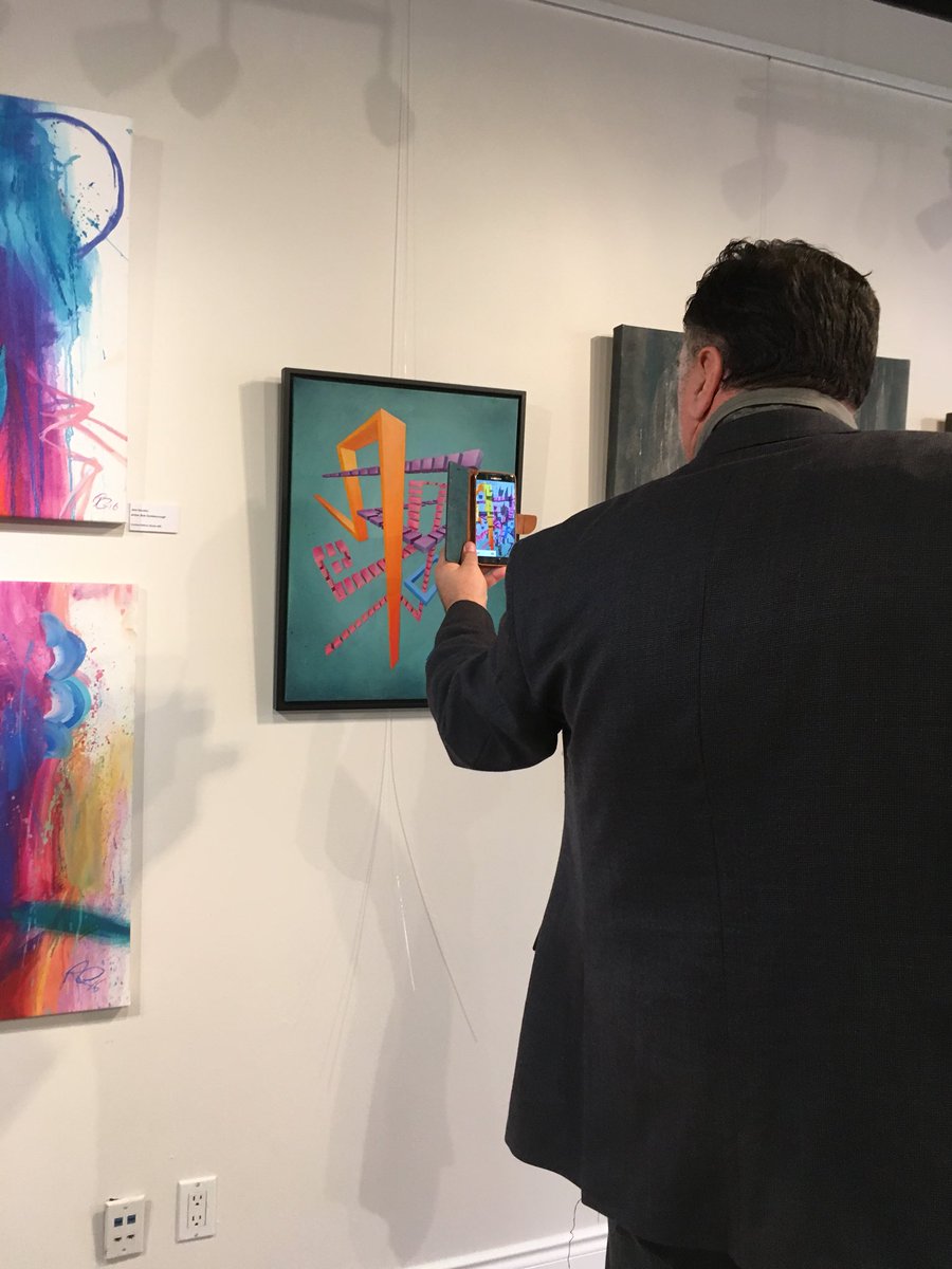 FPGCanada's tweet photo. Raquel Palis is here showing off one of her favourite pieces at our #GrandOpening and is teaching us to use the app, #Artmentation to animate her art. She says it helps her to tell her narrative. #FramePrintGallery #Art https://t.co/LojWIcS9kd
