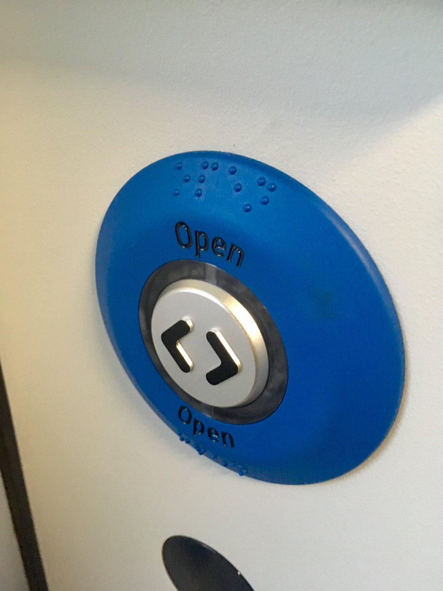 A grey button with a blue ring labelled "Open" and with Braille markings