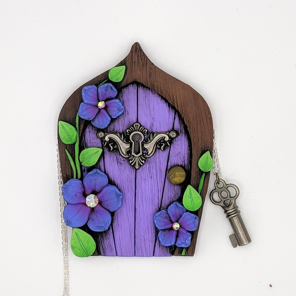 EMTippetts's tweet photo. The last #keyhole door is in my #etsy shop: Little Purple #FairyDoor with Blue and Magenta Flowers, and Key #Necklace; #PixiePortal; #Hobbit Hole; #Gnome, #Elf; #FairyGarden Accessory #sculpture #fairy #fae #fairyportal #jewelry #polymerclay #handmade https://t.co/ynkFNgOMK9 https://t.co/GMXXTFmHSl