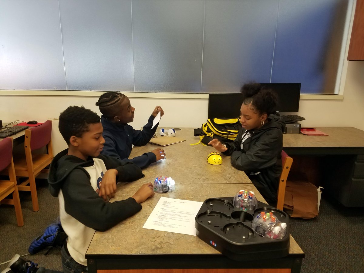 NLA_Pittsburgh's tweet photo. The middle school students practice with each other to prepare for teaching elementary students about robots!

Here we can see Anise teaching DJ and Dontez how to use Beebots.  DJ looks to ask another question while Anise gives instruction. https://t.co/CbGlpswFLV