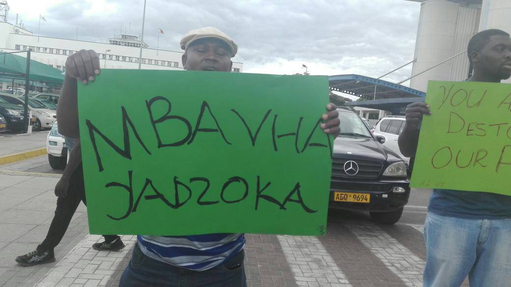 EvansZininga's tweet photo. So Tyson is back in the country to a rowdy welcome by demonstrators . My questions :  On whose payroll are these youngsters? What crime did Savior Kasukuwere commit? Why did he have to run away in the first place? Is it not another Lacoste - G40 Battle( Marry -Go-Round) ? https://t.co/QKD9UiRyaU