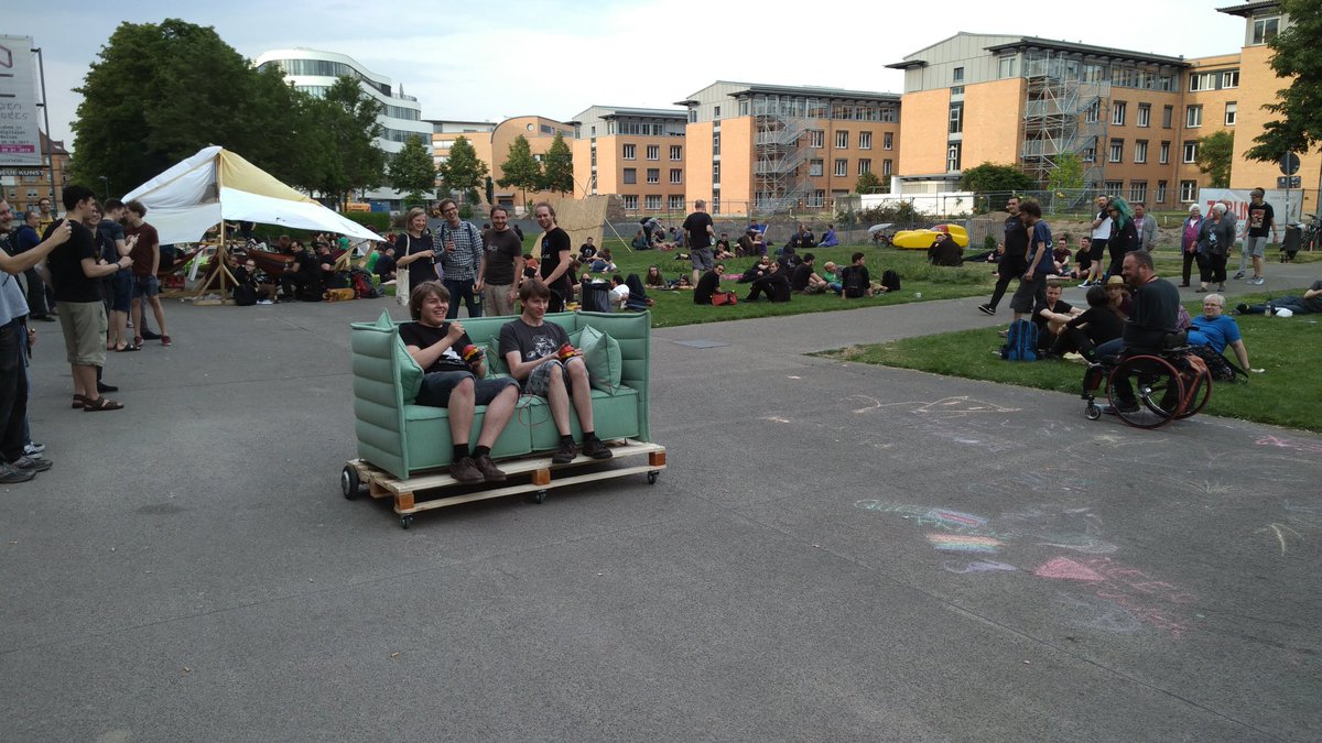 A two person motorised sofa being driven outside the ZKM.