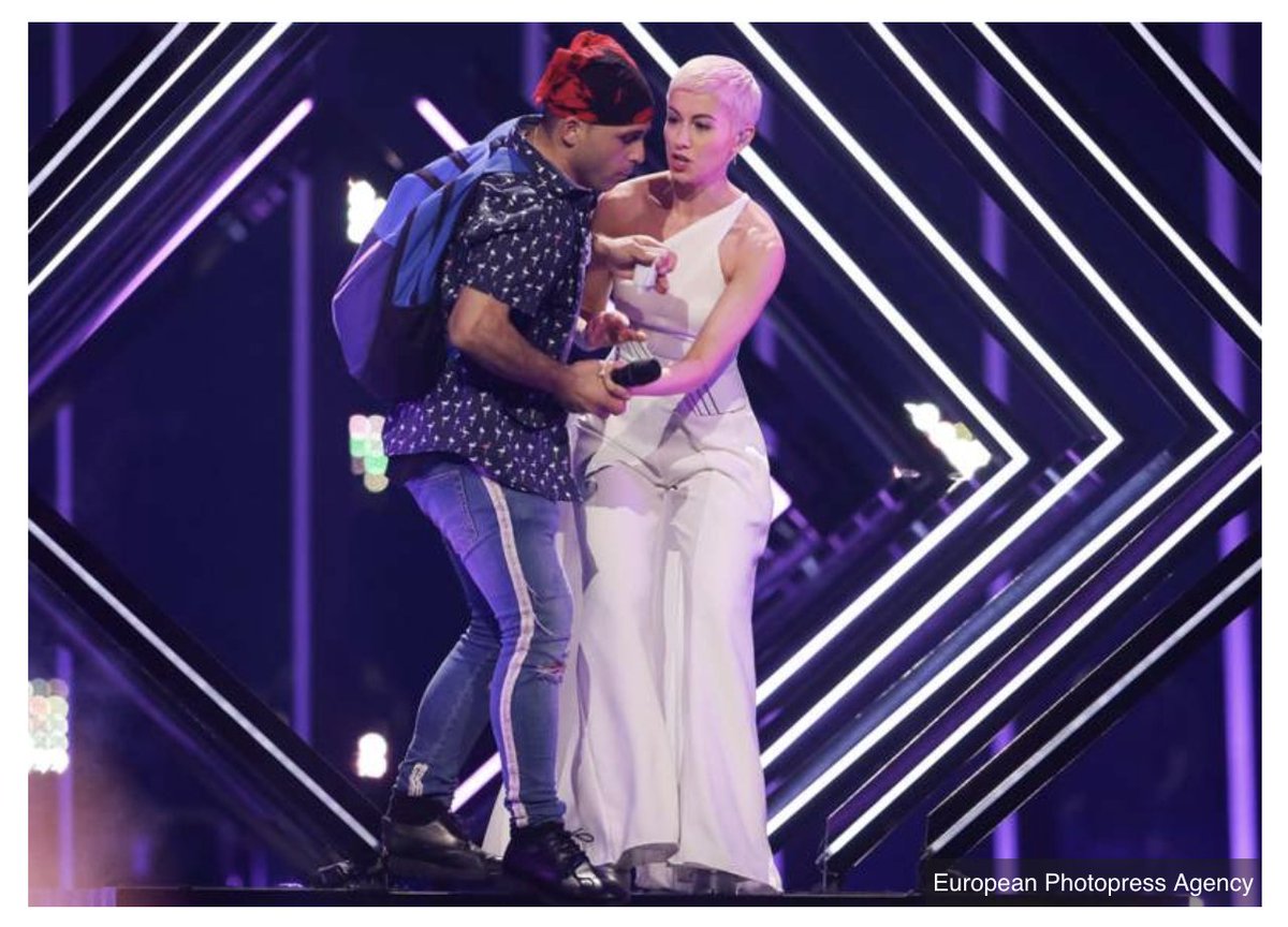 BBCNews's tweet photo. Stage invader interrupts UK's Eurovision performance by @surieofficial 
https://t.co/pe6klR4G6m

Follow our live page for our #eurovision coverage: 
https://t.co/0hXThcsUm0 https://t.co/3KBeE14Rha