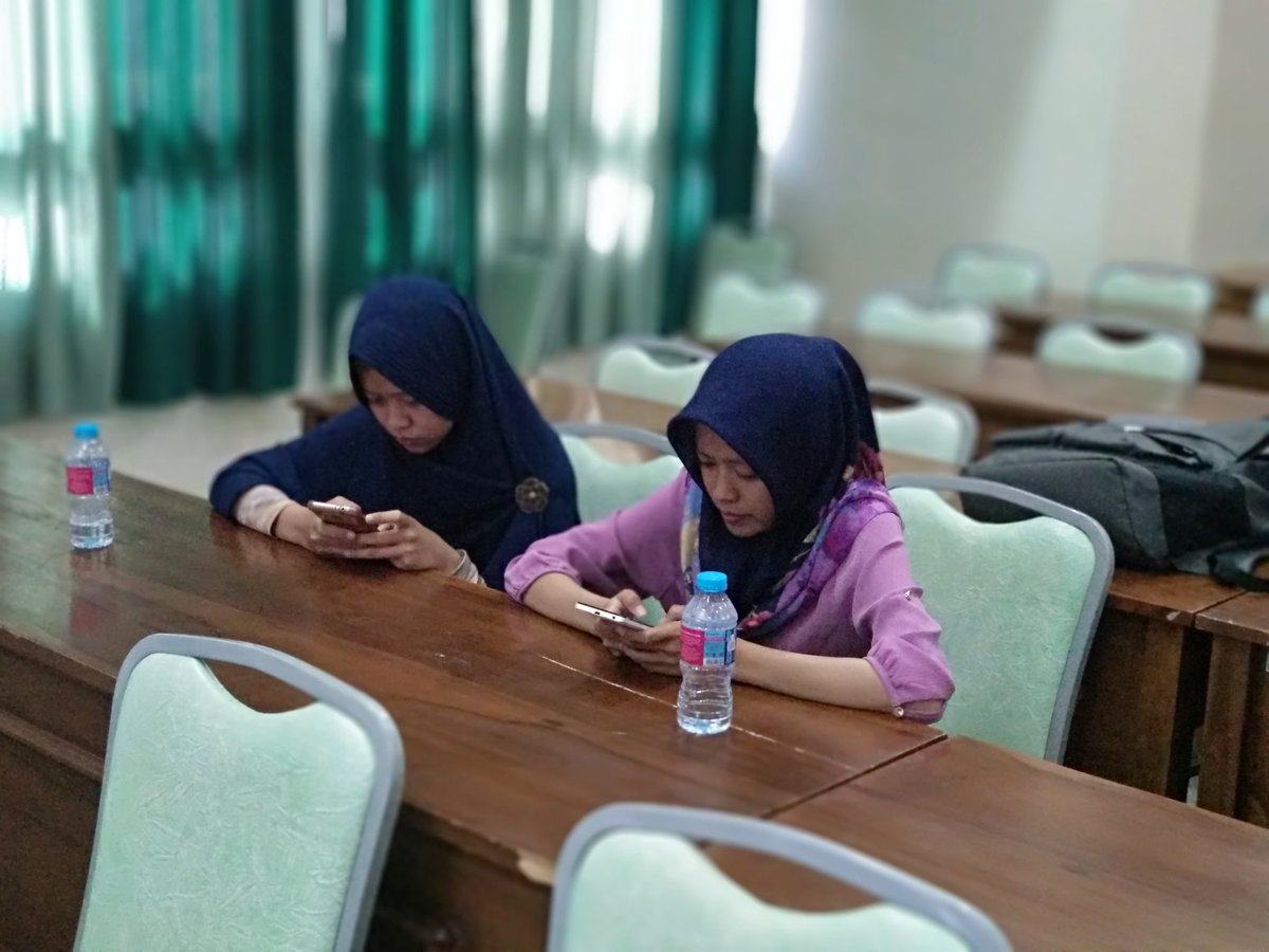 Mereka berdua berdekatan tapi ngobrolnya lewat HP. Hadeuh...