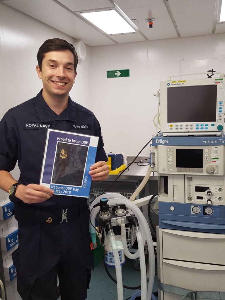 A sailor surrounded by medical equipment and holding an ‘ODP Day’ logo: today is the first national Operating Department Practitioner day.