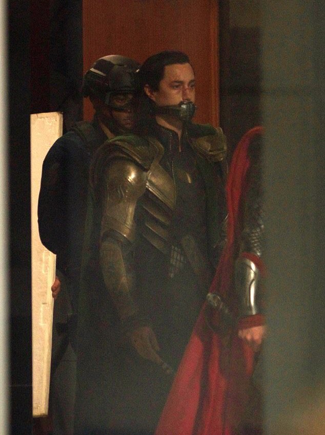 Lokieed's tweet photo. I’M LATE BUT I just realised that this has to be time travel and not a flashback because there are two Tonys in the same place?? (see the door behind loki and tony) ALSO someone removes the muffle and the shackles from loki’s wrists I swear if present Tony talks to past loki IM- https://t.co/FuHOQGqg41