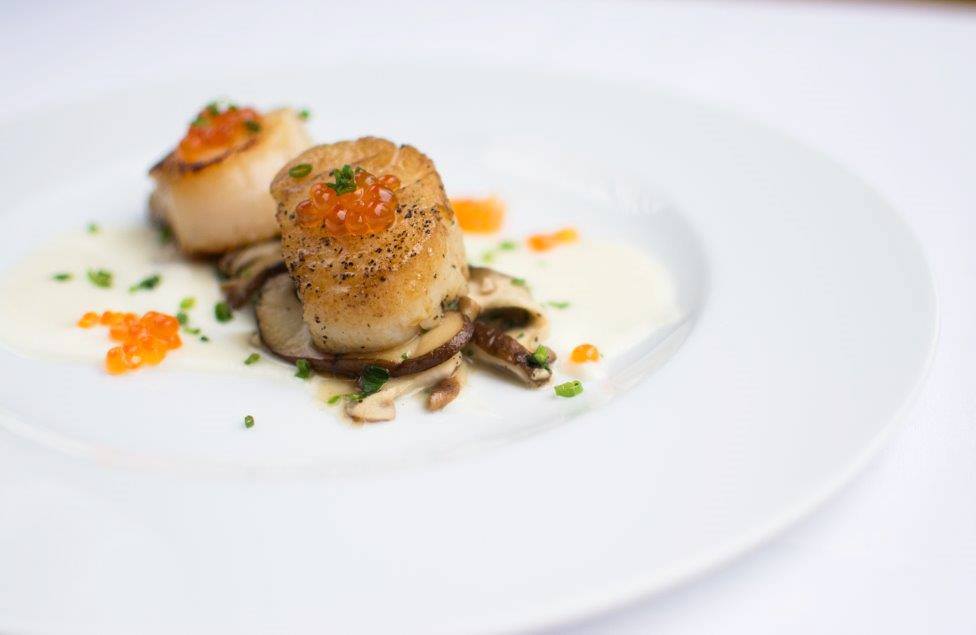 Accompanied with a velvety glass of Chardonnay, out of the shell and onto the fire, our pan seared Scallops feature wild mushrooms and American salmon caviar, sprinkled with chives in a delicate white wine sauce.