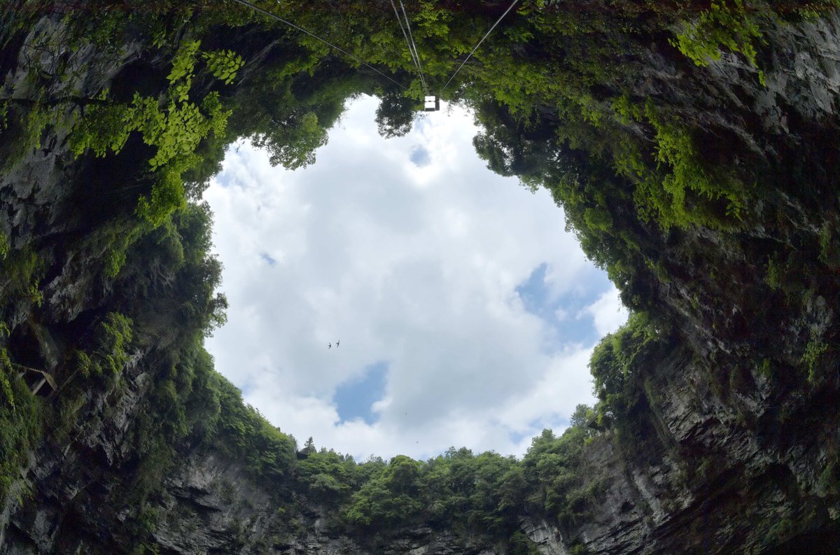 карстовый провал в китае с лесом. карстовая воронка в китае с лесом. воронка в китае с первобытным лесом. карстовая воронка в китае. карстовая воронка в китае.