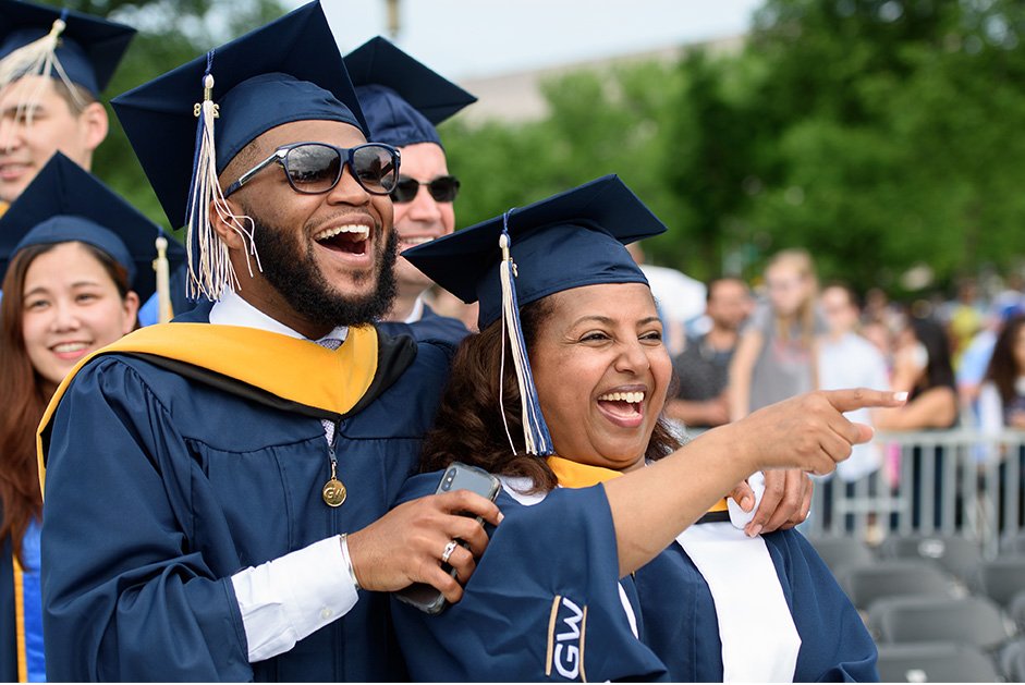 Happy graduates pointing in the distance