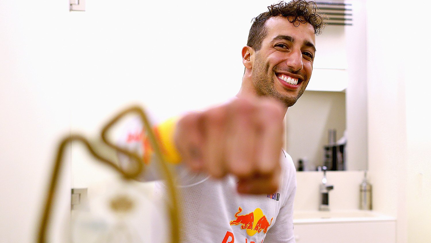 Daniel Ricciardo fist bumps the camera with the Monaco Grand Prix winners trophy.
